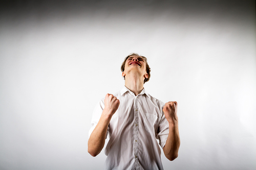 Ein junger Mann ballt die Fäuste und jubelt